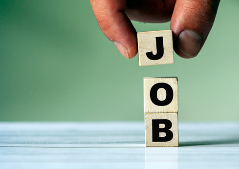 The hand puts the cube block with the inscription JOB. New job or search job symbol