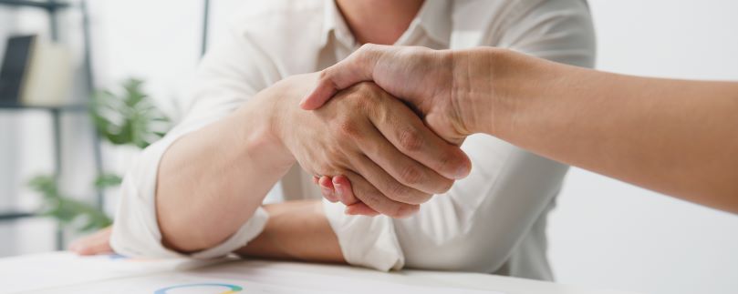 multiracial-group-of-young-creative-people-in-smart-casual-wear-discussing-business-shaking-hands-together
