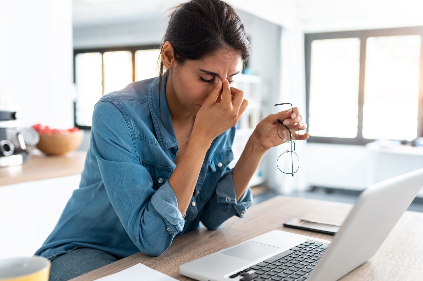 Stressed business woman working from home on laptop looking worried, tired and overwhelmed